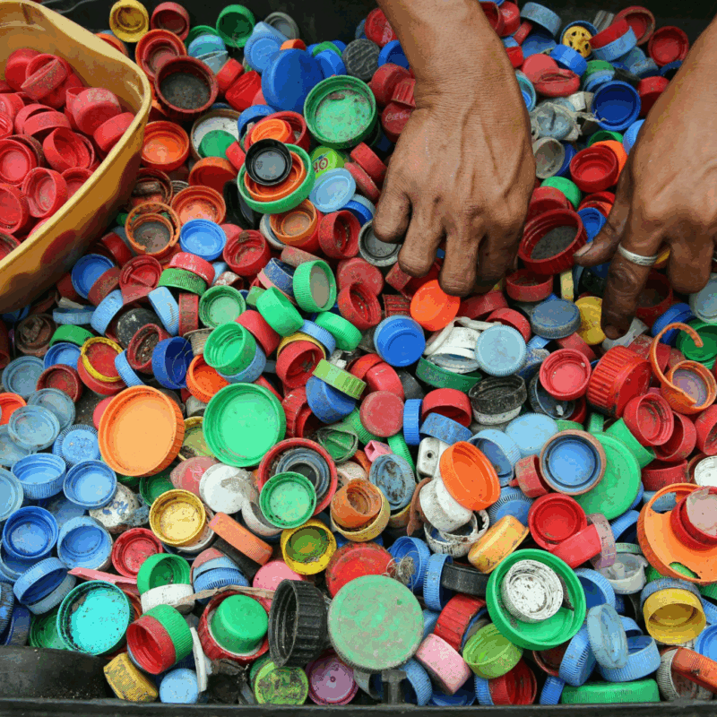 person sorting out bottle caps by colour
